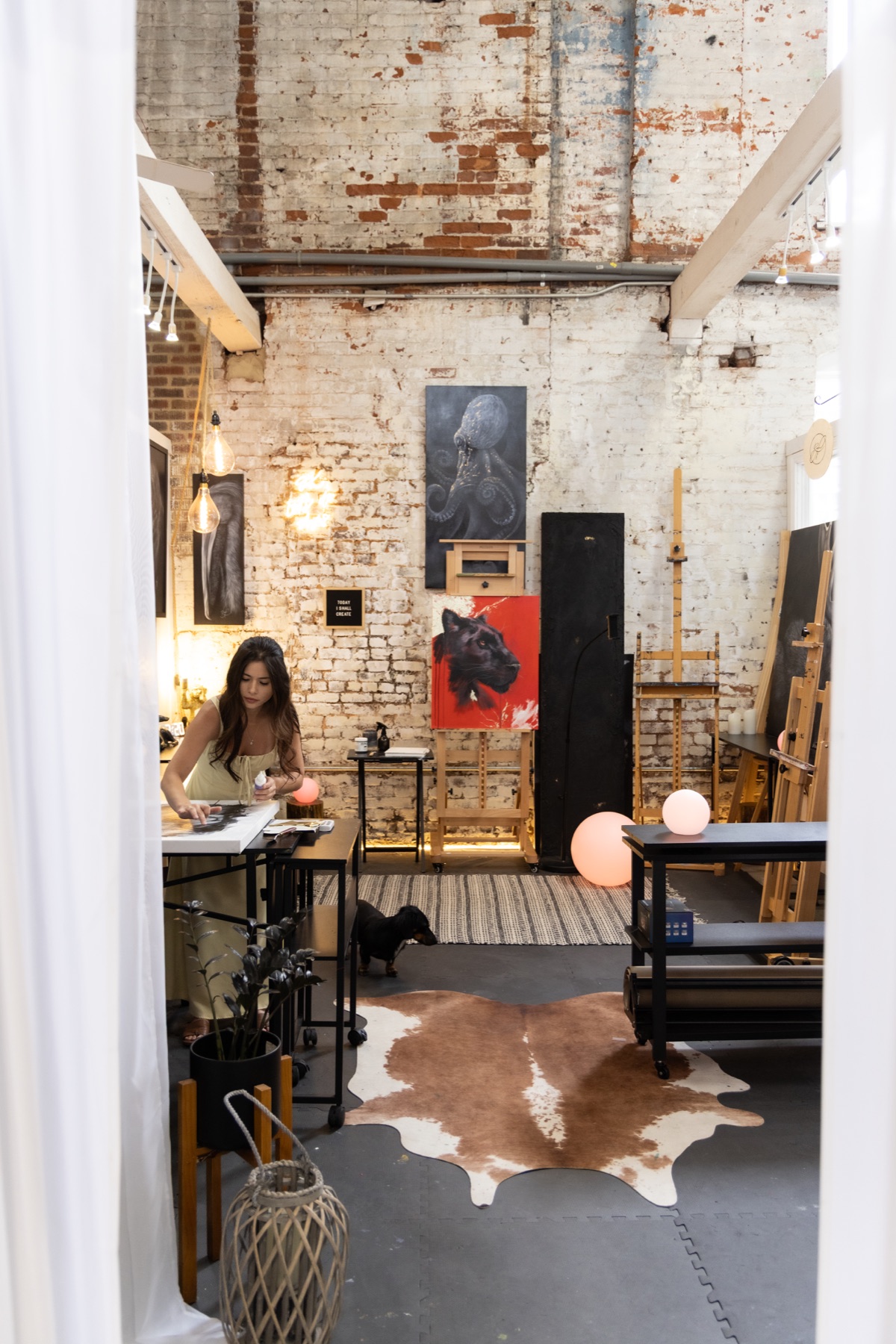 Ashley Rader working among paintings inside her studio